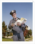 1960s Mailman Holding Letters Mail Leather Mailbag In Suburban Neighborhood by Anonymous