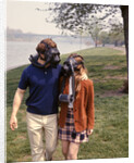 1970s Young Romantic Teenage Couple Man Woman Wearing Gas Masks Walking By River by Anonymous