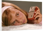 1950s 1960s Teenage Girl Holding Red Silver Small Transistor Radio To Her Ear Listening by Anonymous