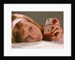 1950s 1960s Teenage Girl Holding Red Silver Small Transistor Radio To Her Ear Listening by Anonymous