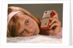 1950s 1960s Teenage Girl Holding Red Silver Small Transistor Radio To Her Ear Listening by Anonymous