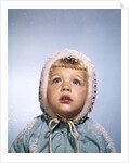 1960s Cold Little Girl In Winter Coat And Hood Looking Up At Falling Snow by Anonymous