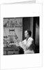 1930s 1940s Woman Scientist In Lab Coat Holding Up And Examining Beaker Of Liquid by Anonymous