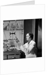 1930s 1940s Woman Scientist In Lab Coat Holding Up And Examining Beaker Of Liquid by Anonymous