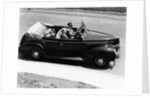 1930s 1940s Couple Driving 1938 Convertible Four Door Sedan Automobile With Luggage In Back Seat by Anonymous