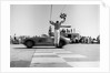 1960s Man Jumping Waving Checkered Flag As Winning Sports Car Crossing The Finish Line by Anonymous