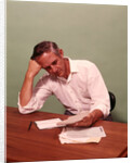 1970s Middle Age Man Sitting At Desk Worried About Bills To Pay by Anonymous