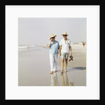 1970s Senior Couple Walking Beach Holding Hands Wearing Straw Hats by Anonymous