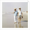 1970s Senior Couple Walking Beach Holding Hands Wearing Straw Hats by Anonymous