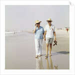 1970s Senior Couple Walking Beach Holding Hands Wearing Straw Hats by Anonymous