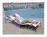 1960s Elegant Tall Woman In Bathing Suit Reclining On A Lounge Chair By Swimming Pool by Anonymous