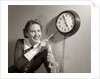 1950s Woman Holding Steno Pad Pointing With Pencil To Clock 5 Minutes Till Quitting Time by Anonymous