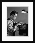 1940s Young Man Office File Clerk Putting Records Into Filing Cabinet Drawer by Anonymous