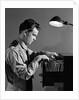 1940s Young Man Office File Clerk Putting Records Into Filing Cabinet Drawer by Anonymous