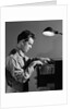 1940s Young Man Office File Clerk Putting Records Into Filing Cabinet Drawer by Anonymous
