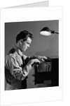 1940s Young Man Office File Clerk Putting Records Into Filing Cabinet Drawer by Anonymous
