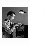 1940s Young Man Office File Clerk Putting Records Into Filing Cabinet Drawer by Anonymous
