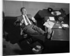 1950s Man Businessman Salesman Eating Lunch In Office With Feet Resting Up On Desk by Anonymous