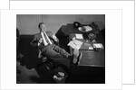 1950s Man Businessman Salesman Eating Lunch In Office With Feet Resting Up On Desk by Anonymous