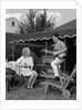 1960s Boy Playing Guitar, Woman Holding Soft Drink Bottle Outside In Backyard by Anonymous