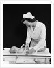 1940s Woman Nurse Changing Baby Diaper In Nursery by Anonymous