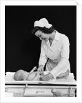 1940s Woman Nurse Changing Baby Diaper In Nursery by Anonymous
