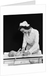 1940s Woman Nurse Changing Baby Diaper In Nursery by Anonymous