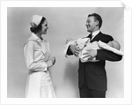 1930s 1940s Woman Nurse Talking With Man Proud New Father Holding Newborn Twin Babies by Anonymous