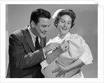 1950s 1960s Man New Father Looking At Baby Held By Woman Nurse by Anonymous