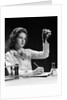 1940s Student Nurse Holding Up Test Tube While Taking Notes In Science Class by Anonymous