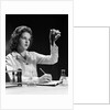1940s Student Nurse Holding Up Test Tube While Taking Notes In Science Class by Anonymous