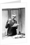 1930s Elderly Man In Office Standing Behind Desk Gesturing With Raised Finger by Anonymous