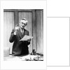 1930s Elderly Man In Office Standing Behind Desk Gesturing With Raised Finger by Anonymous