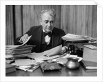 1920s 1930s Elderly Executive Man Sitting At Desk Looking Through Papers by Anonymous