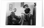 1940s Woman Sitting On Desk Hat Skirt Hand Gesture Talking Flirting With Man by Anonymous