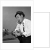 1960s Reporter With Hat On Phone At Typewriter by Anonymous