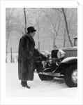 1930s Man In Hat And Raccoon Fur Coat Standing Foot On Bumper Of Chevrolet Roadster Stalled In Snow Storm by Anonymous