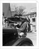 1930s Service Station Attendant In Cap and Coveralls Pouring Water From Spouted Can Into Automobile Radiator by Anonymous