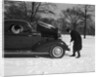 Woman Passenger Watching Man Motorist Try To Crank Start A Chevrolet Coupe Stalled In Snow by Anonymous