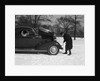 Woman Passenger Watching Man Motorist Try To Crank Start A Chevrolet Coupe Stalled In Snow by Anonymous