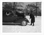Woman Passenger Watching Man Motorist Try To Crank Start A Chevrolet Coupe Stalled In Snow by Anonymous