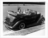 1940s Family Of Four In Convertible Ford V-8 Sedan At Camera by Anonymous