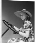 1930s 1940s Woman Wearing Straw Hat Sun Dress Driving Gloves Holding Auto Mobile Steering Wheel Looking At Camera by Anonymous
