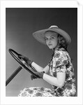 1930s 1940s Woman Wearing Straw Hat Sun Dress Driving Gloves Holding Auto Mobile Steering Wheel Looking At Camera by Anonymous