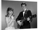 1960s Teenage Entertainment Duo Man Playing Guitar And Woman Singing Holding Microphone by Anonymous