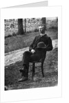 1890s 1900s Side View Of Man Wearing Suit Seated On Chair Outside Holding Bowler Hat by Anonymous