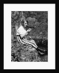 1920s Young Woman In Striped Skirt Sitting On Stream Bank In Woods Braiding Garland Of Wild Flowers by Anonymous