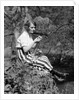 1920s Young Woman In Striped Skirt Sitting On Stream Bank In Woods Braiding Garland Of Wild Flowers by Anonymous