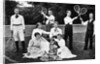 1890s 1900 Men Holding Racquets and Women and One Child In Front Of Net On Grass Tennis Court by Anonymous