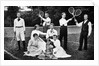 1890s 1900 Men Holding Racquets and Women and One Child In Front Of Net On Grass Tennis Court by Anonymous